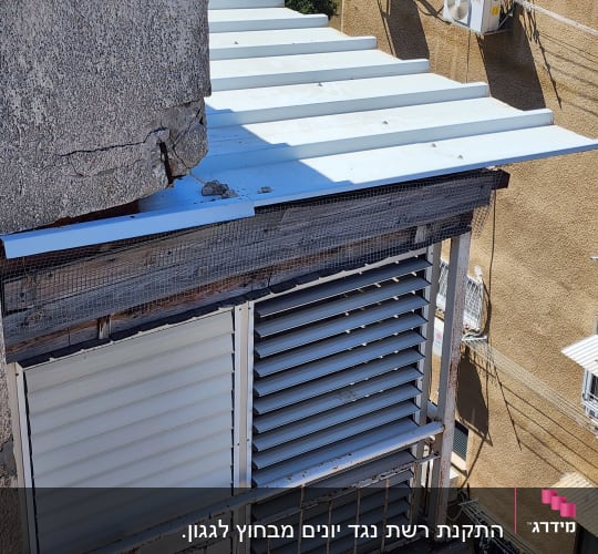 רשת מתכת מותקנת למניעת כניסת יונים לגג